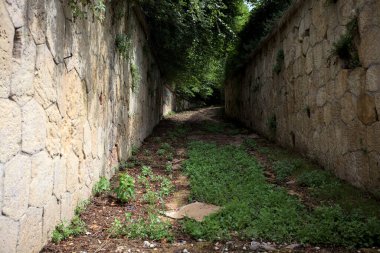 Parktaki taş duvarlar arasındaki boş toprak patika