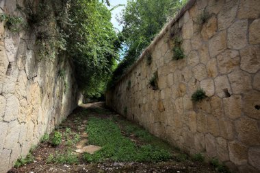 Parktaki taş duvarlar arasındaki boş toprak patika