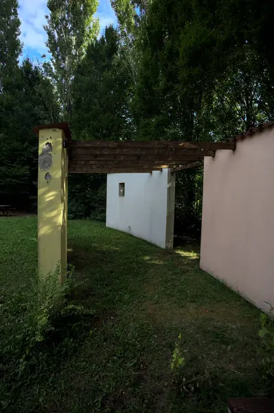 Parktaki bir grup ağacın arkasındaki ev cephesi şeklinde sanatsal kurulum