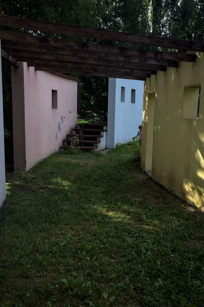 Parktaki bir grup ağacın arkasındaki ev cephesi şeklinde sanatsal kurulum