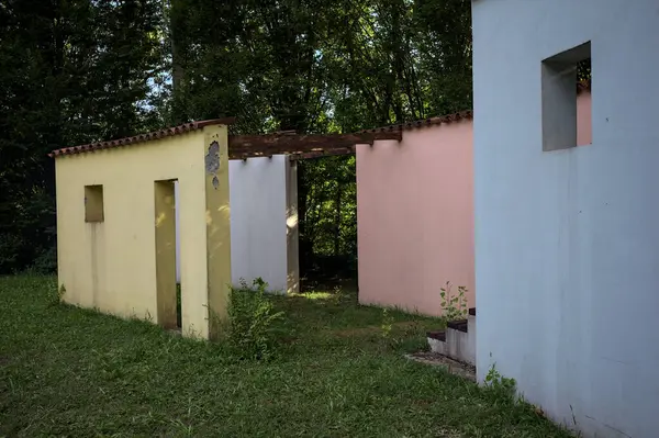 Parktaki bir grup ağacın arkasındaki ev cephesi şeklinde sanatsal kurulum