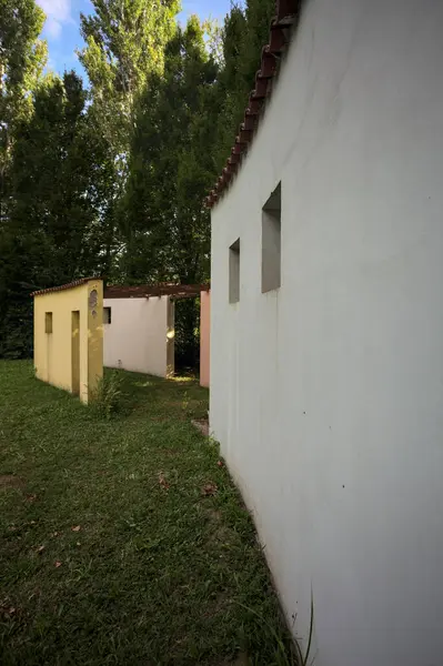 Parktaki bir grup ağacın arkasındaki ev cephesi şeklinde sanatsal kurulum