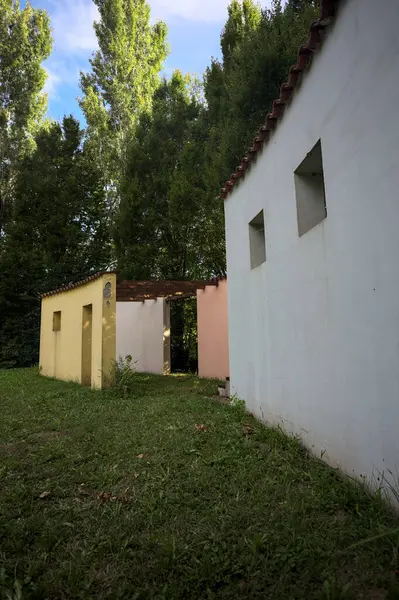 Parktaki bir grup ağacın arkasındaki ev cephesi şeklinde sanatsal kurulum