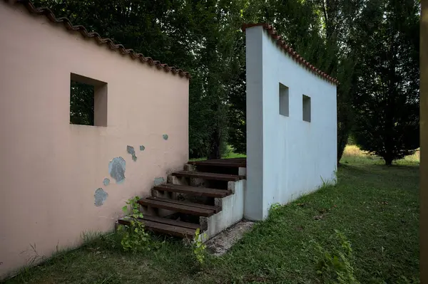 Parktaki bir grup ağacın arkasındaki ev cephesi şeklinde sanatsal kurulum