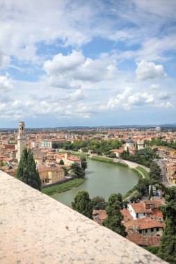 Verona, İtalya - 30 Temmuz 2025 - Adige Nehri Verona 'dan geçiyor Katedralin çan kulesi nehir kıyısındaki binalardan filizleniyor