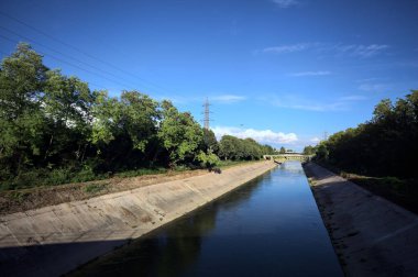 Günbatımında İtalya kırsalında ağaçlarla çevrili saptırma kanalı