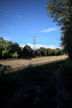 Günbatımında İtalya kırsalında ağaçlarla çevrili saptırma kanalı