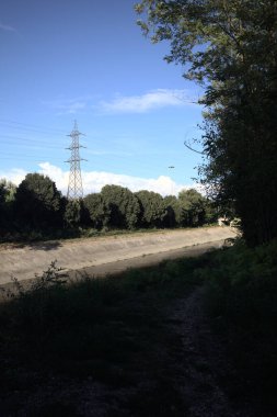 Günbatımında İtalya kırsalında ağaçlarla çevrili saptırma kanalı