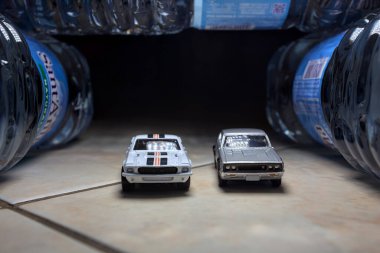 Mantova, İtalya - 28. AĞUSTOS 2025 - Ford GT Shelby 500 ve Nissan Skyline 2000GT-R 'ın kopyaları bir tünelde yarışıyormuş gibi davranıyorlar.