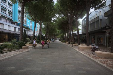 Milano Marittima, İtalya - 22 ND SEPTEMBER 2025 - Bulutlu bir günde dükkanları ve deniz çam ağaçlarıyla çevrili neredeyse boş bir bulvar