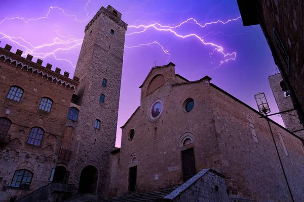 stock image view during a thunderstorm with lightning of the big tower and town hall of the town of san gimignano in tuscany