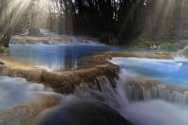 tuscany series of waterfalls produced by the elsa river with fog and sunbeams