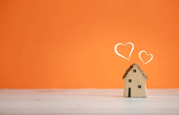 home sweet home, home model with two white hearts above on orange color background