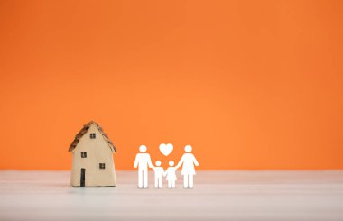 Evim güzel evim, turuncu arka planda aile ikonu olan ev modelim.