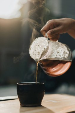 Kahve dükkanında filtreli kahve yapıyorum. Bir damla sıcak espresso hazırlamak, sıcak suyla kahvenin üzerine dökmek ve evde filtre kağıdı dökmek..