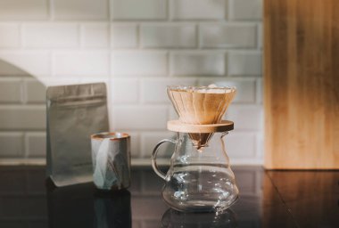 Kahve dükkanında filtreli kahve yapıyorum. Bir damla sıcak espresso hazırlamak, sıcak suyla kahvenin üzerine dökmek ve evde filtre kağıdı dökmek..