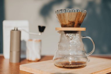 Kahve dükkanında filtreli kahve yapıyorum. Bir damla sıcak espresso hazırlamak, sıcak suyla kahvenin üzerine dökmek ve evde filtre kağıdı dökmek..