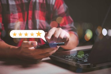 Akıllı telefon kullanan adam 5 yıldızlı not veriyor, müşteri memnuniyeti kavramı