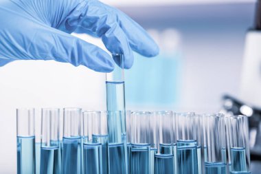 Kimyager, bilim adamı el, laboratuvar arka planındaki test tüpünü, bilim araştırma ve geliştirme konseptini aldı.