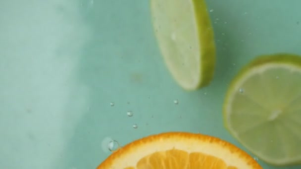 Яркие Ломтики Апельсина Лайма Лениво Танцуют Воде Цитрусовые Плавают Движения — стоковое видео