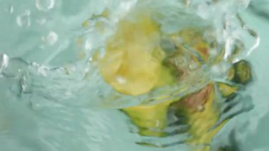 Yukarıdan aşağıya doğru bakan bir avacado zarif bir şekilde suya iner ve damlacıkların her yöne dağılmasına neden olur. Avacado 'nun battığı ve gözden kaybolduğu o büyüleyici anı tecrübe edin..