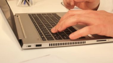 Laptop klavyesinde özenle yazan birey, görevine odaklanmış durumda. Hassasiyet ve hızla, ana araçları olarak dizüstü bilgisayarı kullanarak dijital alanda geziniyorlar.. 
