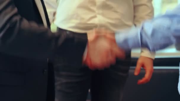 会議室では ビジネスの服装の3人の男性が 取引を密封するためにしっかりと握手をしています ハンドシェイクは信頼と合意を象徴しています 自信を持った握手は相互尊重を意味します — ストック動画