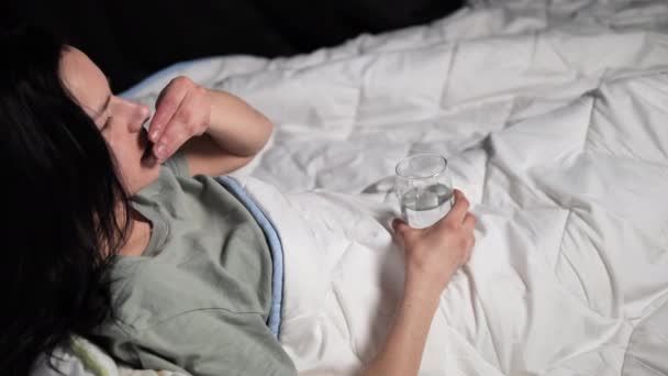 Uma Jovem Morena Deita Calmamente Cama Tomando Sua Medicação Prescrita — Vídeo de Stock
