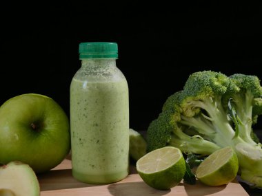 Avokado, limon, brokoli, elma salatalığı ile çevrili taze yeşil smoothie. Meyve suyu meraklıları için ideal sağlıklı beslenme ve sağIık videoları içeriğinizi bu besleyici smoothie ile güçlendirir..