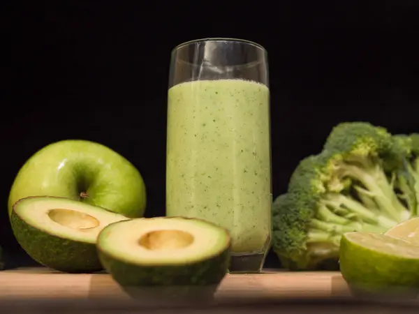 Avokado limonlu, brokolili, elmalı, salatalıklı taze yeşil smoothie. Sağlıklı beslenmek, sağlıklı beslenmek ve detoks için ideal bir içecek. Besleyici bileşenler ve bu meyve suyunun ferahlatıcı tadı..