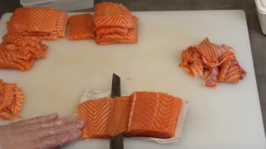 Usta şef bıçağını somon balığının içinden geçirir, pürüzsüz, hatta dilimlere ayırır. Her parça somon, şeflerin detaylara olan ilgisini ve somon balığı tutma sanatını yansıtır..