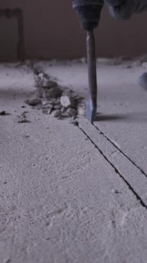 Çekiçle yapılan matkabın yakın çekimi betonu titizlikle delip geçiyor. Çekiç matkabı her katmana güç verir. Bu da aletlerin dayanıklılığını ve verimliliğini gösterir..