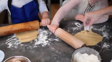 Önlüklü çocuklar para kazanıyor, yuvarlanıyor ve şekillendiriyorlar. Her çocuk hamuru heyecanla kavrar, yoğurmayı, şekil vermeyi öğrenir ve şaşaalı eller altında yuvarlanır..