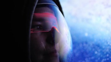 Astronot, yüksek teknolojili miğfer vizöründen Dünya 'ya bakıyor. Yüzüne yansıyan kırmızı ışıklar. Gelişmiş teçhizat astronotların görüşünü arttırır, uzayla büyüleyici bir bağlantı yaratır. 
