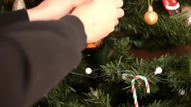 İnsan Noel 'i altın ve kırmızı süslemelerle süslenmiş ağaca takar. Şeker kamışları ve şenlik ışıklarıyla. Tatil sezonuna cazibe ve sıcaklık katar.. 