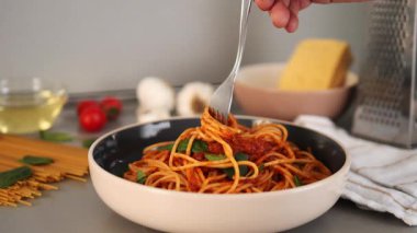 Taze domatesler, aromatik sarımsak, parmesan peyniri, kokulu fesleğen, çiseleyen zeytinyağı içeren taze malzemelerle çevrili, çatallı dengeli İtalyan makarnası.