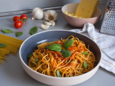 Domates soslu ve taze fesleğen yapraklı Balanesi makarnası leziz bir mutfak sahnesi yaratır. Lezzetli Balanesi makarnası modern kasede Balanesi makarna sunumu zengin dokuları ön plana çıkarıyor. 