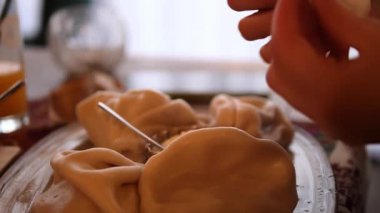 Bir şefe nazikçe baharat ekleyin geleneksel Gürcistan hamur tatlısı, bir tabakta, lezzetlerini artırmak için.