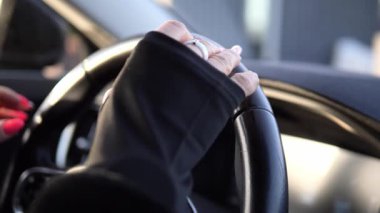 Direksiyon makinası, siyah parmaksız deri eldivenler giyen, kendine güvenen ve kontrol eden kadın sürücüler tarafından sıkıca kavrandı. Direksiyon Makinesi düzgün bir şekilde hareket ediyor.