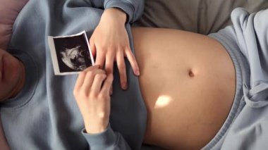 Müstakbel anne huzur içinde yatarken ultrason görüntüsü karnına nazikçe yerleştirildi. Ultrason görüntüsü hassas bağı yakalar, ultrason görüntüsü sakin doğum öncesi bağlantıyı güçlendirir. 