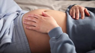 Müstakbel anne yatakta rahat bir şekilde uzanıyor, şefkatle büyüyen karnını okşuyor sevgi dolu elleriyle, annelik bağını somutlaştırıyor ve yeni bir hayat beklentisi besliyor.