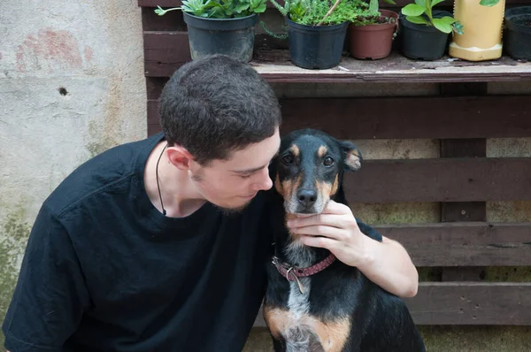 年轻人和他的狗在后院的房子里 生活方式人们的概念 — 图库照片