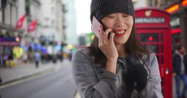 Neşeli bir milenyum kadını cep telefonuyla konuşuyor ve Londra 'da ısınmaya çalışıyor. Mutlu Asyalı genç turist Avrupa 'da soğukta akıllı telefondan sohbet ediyor. 4k
