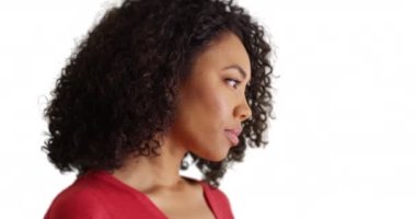 Üzgün yüzlü sevimli Afrikalı kadın beyaz arka planda kameraya gülümsüyor. Telif alanı olan dalgın genç bayana yakın çekim. 4k