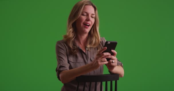 中年白人妇女在绿色屏幕上看智能手机上的图片 在绿色屏幕上键入或合成 — 图库视频影像