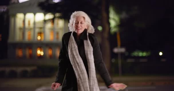 Безтурботна Старша Жінка Танцює Шарфом Житловій Вулиці Ввечері Посміхаючись Літня — стокове відео