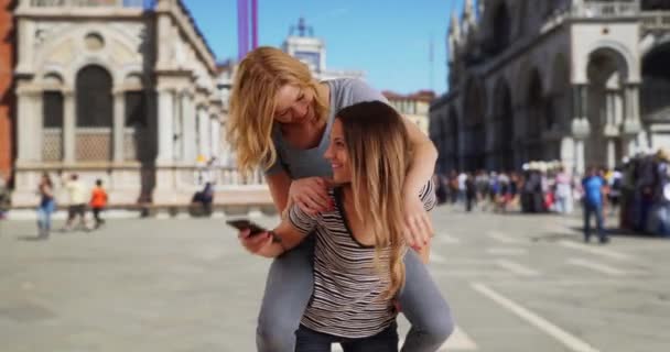 Ελκυστική Νεαρή Ξανθιά Γυναίκα Εκπλήσσει Φίλη Της Πηδώντας Στην Πλάτη — Αρχείο Βίντεο