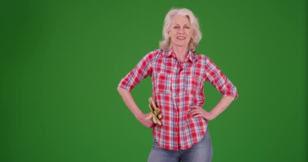 Elleri Kalçasında Yeşil Ekranda Bahçe Eldivenleri Tutan Gururlu Yaşlı Kadın — Stok video