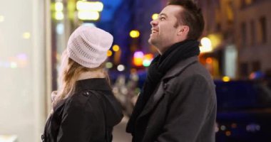 Geceleri Paris caddesinde birbirine aşık çift alışverişi yapıyor. Beyaz adam ve kadın dışarı bakıp gülümsüyor. 4k