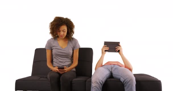 夫妇使用科技坐在沙发上隔离在白色背景 — 图库视频影像